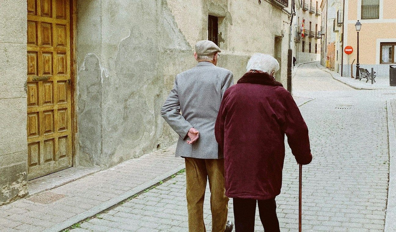 elderly couple walking in village in Spain 