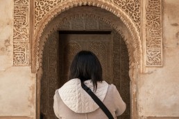 Brunette woman standing in front of arabic style architecture in Spain
