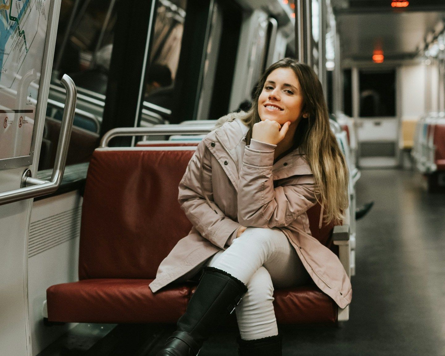 young woman smiling while traveling alone on train