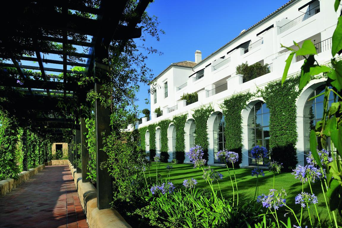 Vibrant green gardens lining arches and pathways at Finca Cortesin in Marbella
