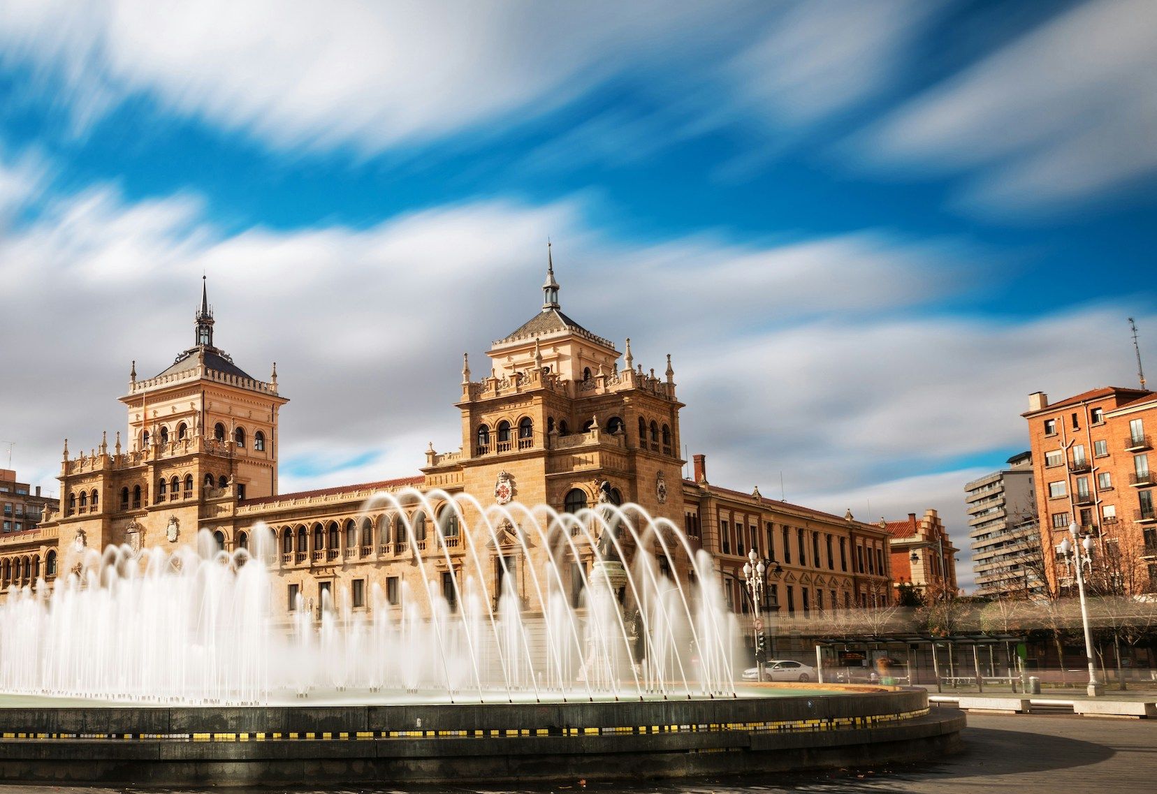 Central fountain Plaza Zorrilla in Valladolid with Calvary academy building in the background.